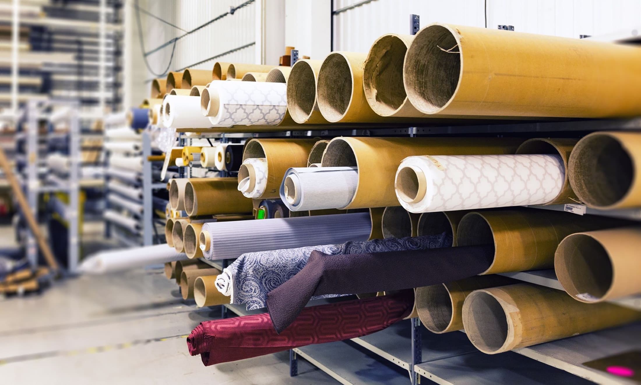 Rolls of fabric stacked on shelves in a textile warehouse