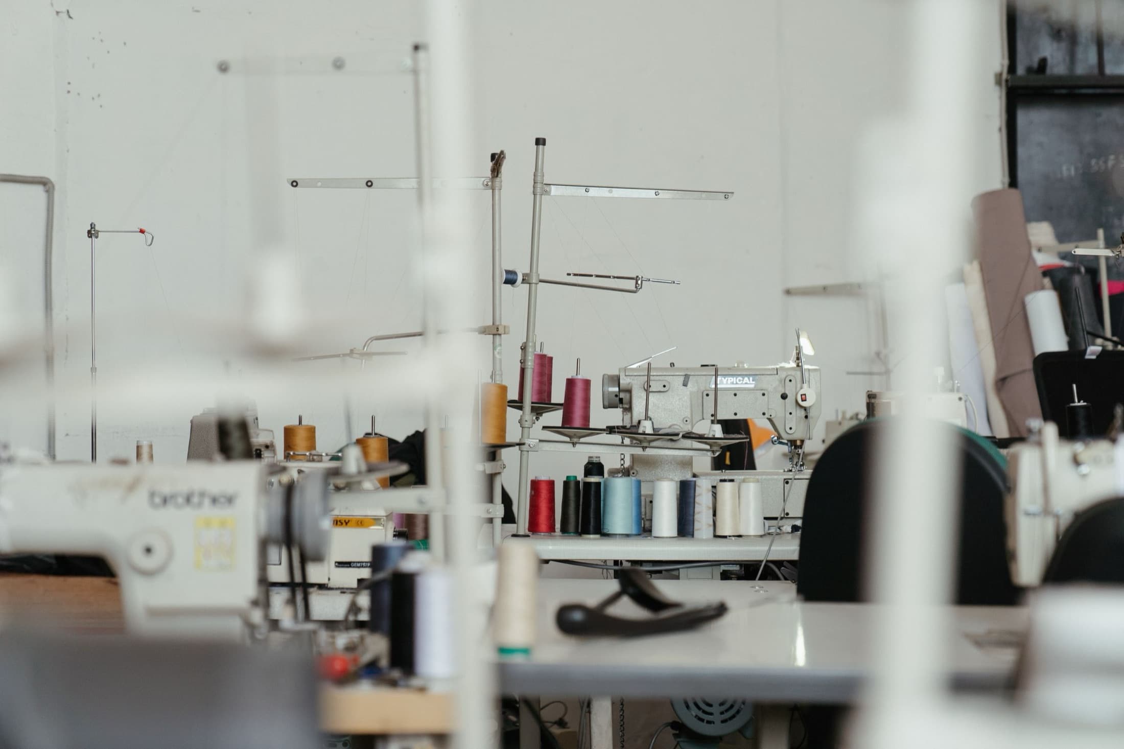 Bright sewing atelier with industrial machines and thread spools