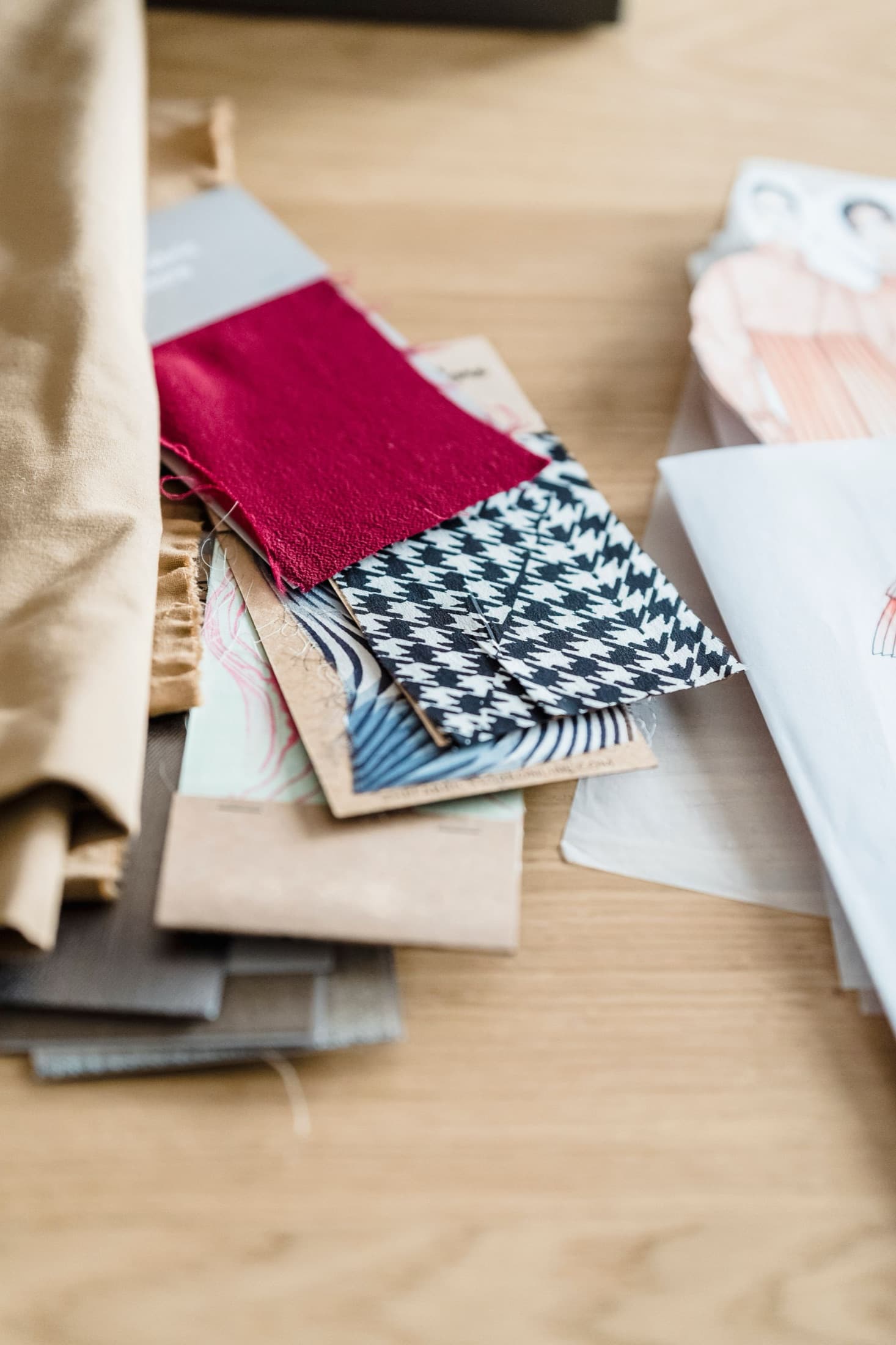 Fabric swatches including houndstooth and solid wovens laid on a table